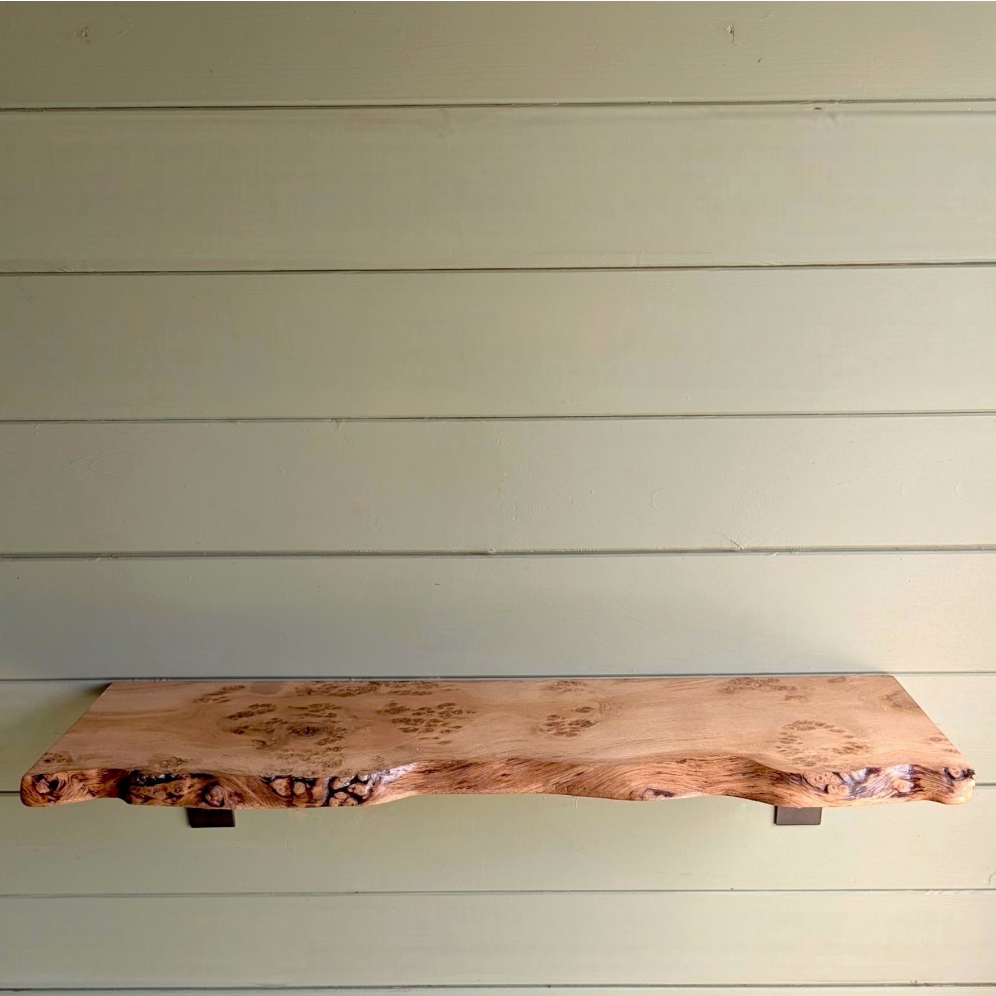 Thriverton hand-crafted pippy oak shelf with a natural live-edge profile and expressive wood grain on a green wall