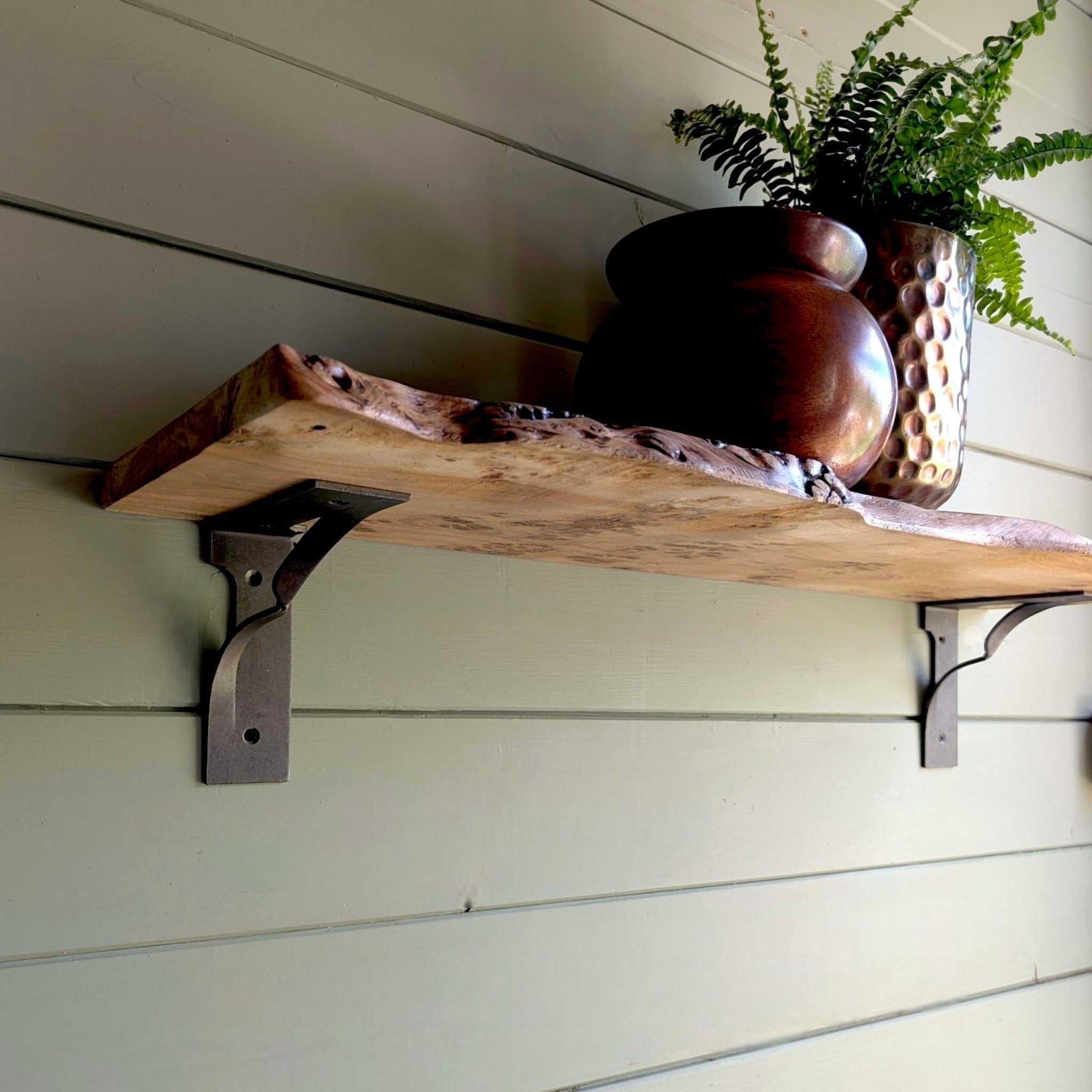 Thriverton live edge pippy oak shelf with traditional twist cast iron brackets mounted on a sage green wall