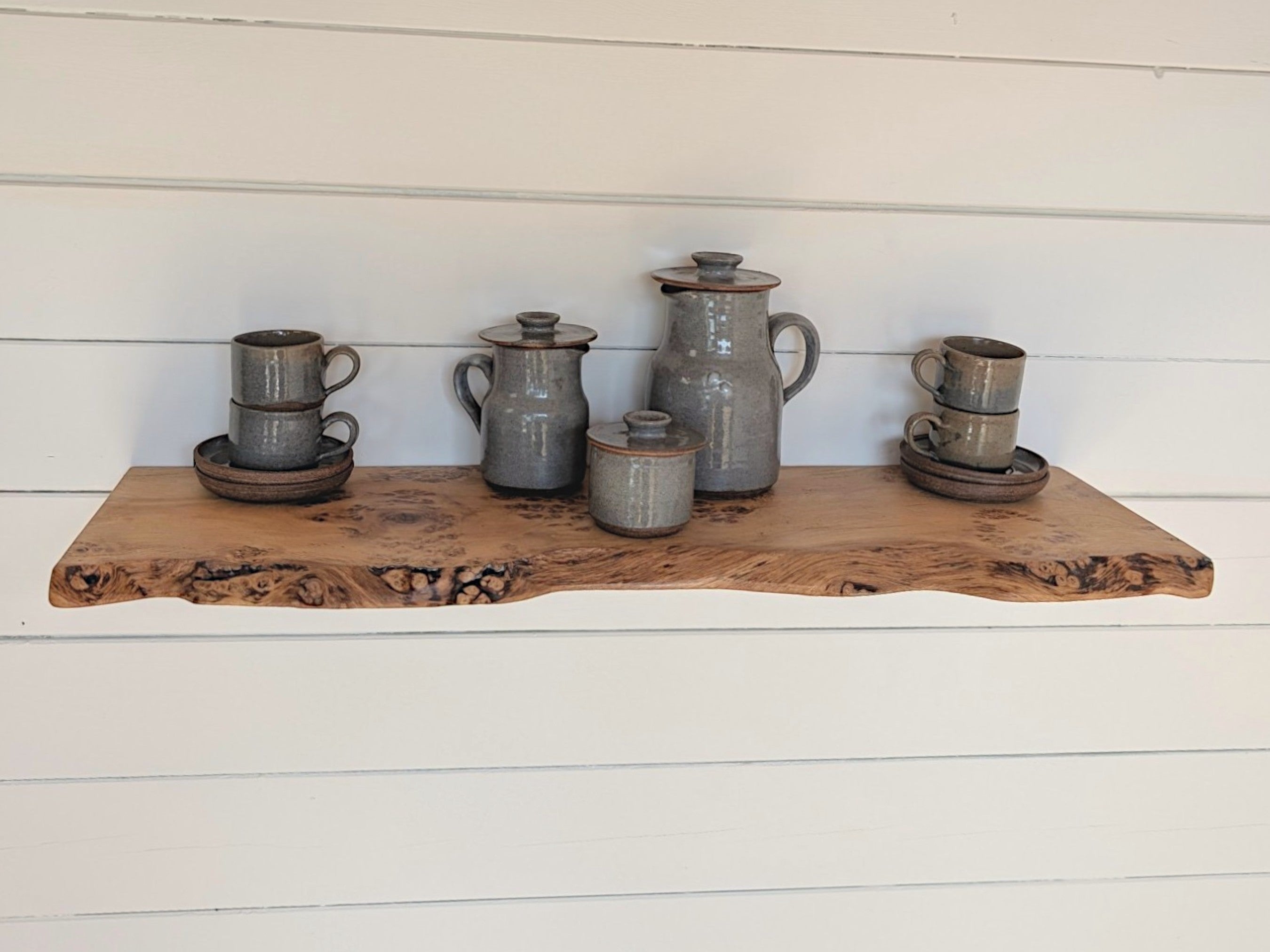 Thriverton live edge pippy oak shelf with natural wood grain and pips, mounted on a white shiplap wall with ceramics.